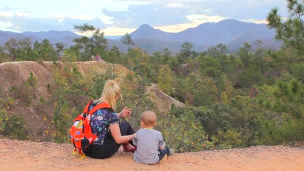 Madre e hijo sentados en una colina — Vídeo de stock