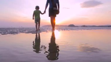 Baba ve oğul sahilde yürüyor.