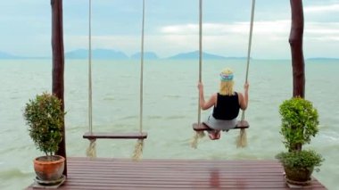 Kız sahilde salıncağa sallanan