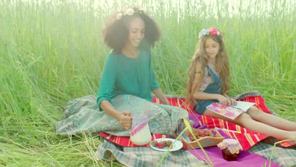Dziewczyny siedzą w polu i picie mleka — Wideo stockowe