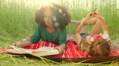 Young girls lying on cover and reading
