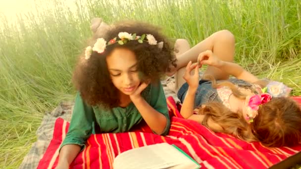 Chicas jóvenes tumbadas en la cubierta y leyendo — Vídeos de Stock