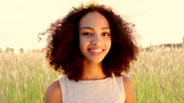 Primer plano de la joven niña con corona de flores en la puesta del sol — Vídeos de Stock