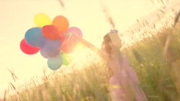 Fille courir avec des ballons de vacances pendant le coucher du soleil — Video