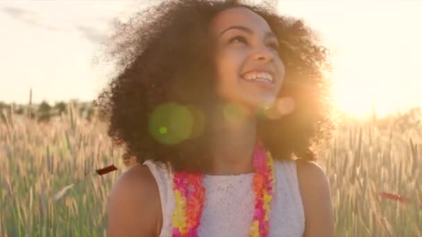 Young girl enjoying confetti rain in the wheat field during sunset — Stock video