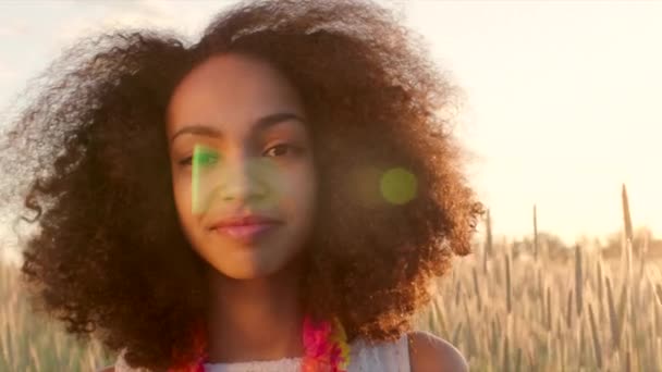 Portret van een jong meisje in het tarweveld tijdens zonsondergang — Stockvideo