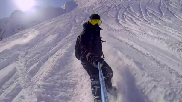 Selfie gopro 棒彼の手でスノーボードに乗る男 — ストック動画