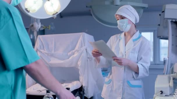 Cirurgião que olha através dos papéis dos pacientes — Vídeo de Stock