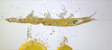 Yavaş hareket eden portakallar suya sıçrar. Canlandırıcı ve canlı makro görüntüler. Yüksek kaliteli FullHD görüntüler