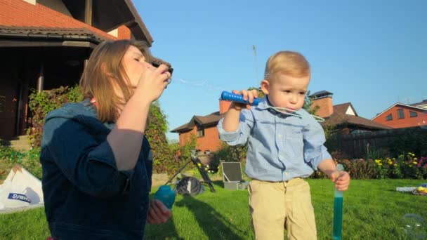 Mutter und Sohn pusten Seifenblasen — Stockvideo