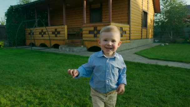 Pequeño niño corriendo en el césped — Vídeo de stock