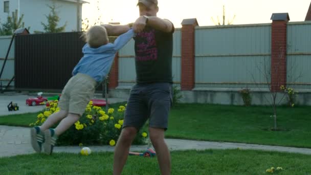 Vader en zoon spelen op de achtertuin — Stockvideo