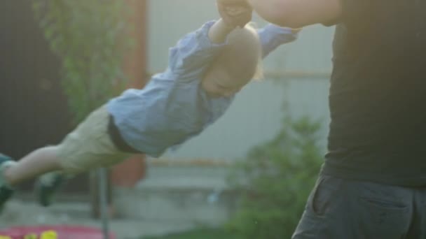 Mały chłopiec latający w rękach ojców — Wideo stockowe