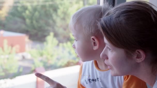 Moeder en zoon kijkt uit het raam vreemd genoeg — Stockvideo