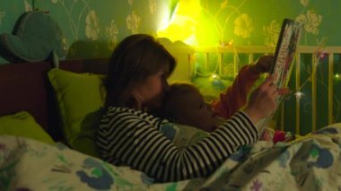 Anne ve oğul yatakta kitap okumak