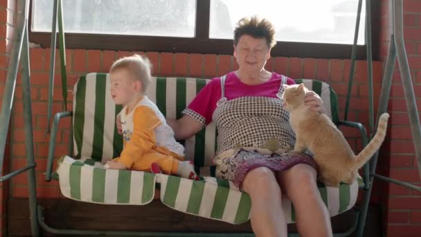 Chlapce a babička na zahradní houpačka lavička — Stock video