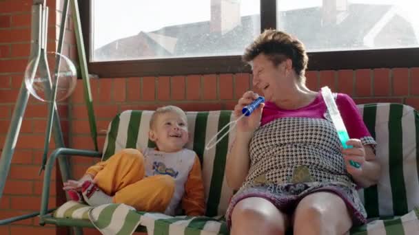 Boy and Grandmother Playing with Soap Bubbles — Stock Video