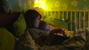 Çocuk ve annesi yatakta çizgi film izlerken