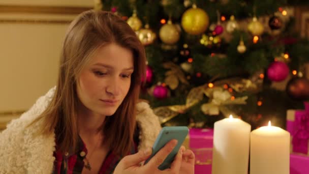 Woman with Smartphone by Christmas Tree — ストック動画