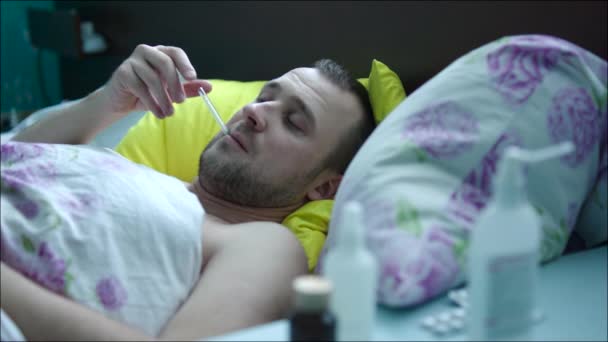 Kranker Mann nimmt Temperatur und hustet — Stockvideo