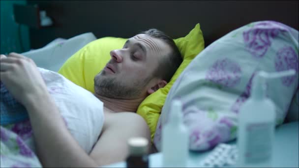 Хворий чоловік лежить в ліжку — стокове відео