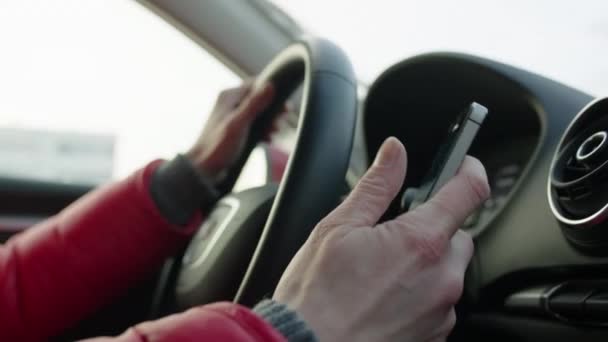 Женщина пишет смс за рулём машины — стоковое видео
