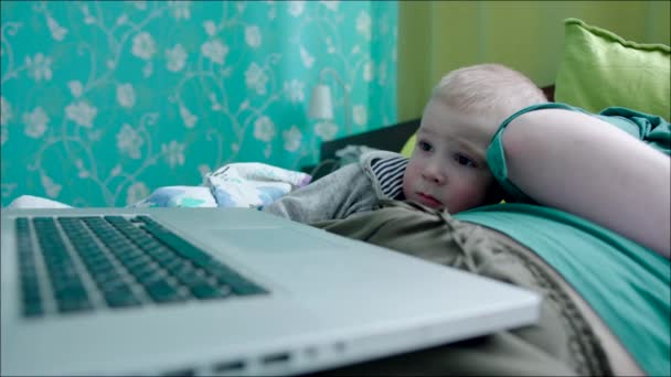 Menino assistindo desenhos animados no laptop na cama — Vídeo de Stock