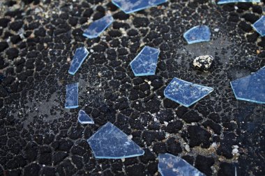 Shards of glass on the asphalt surface