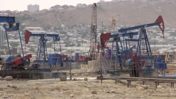 Нефтяные насосы в действующем нефтяном месторождении — стоковое видео