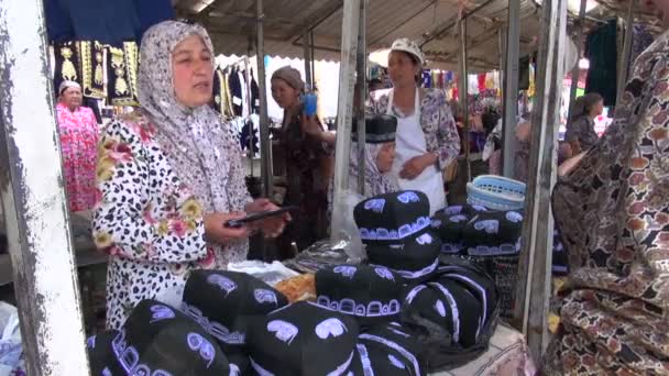 A woman is selling male muslim skullcaps — Stock Video