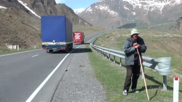 Pastýř stojí u silnice v Gruzii. — Stock video