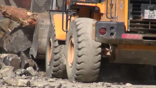 Graafmachines duidelijke rotsen en bomen — Stockvideo