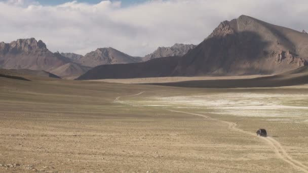 Jeep traverses an arid valley — стоковое видео