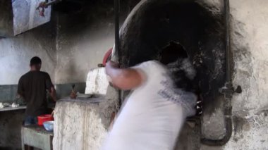 Bir fırıncı ekmek, Tandır fırını koyar.