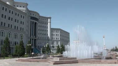 Bir adam etkileyici çeşmelerin yanından geçiyor.