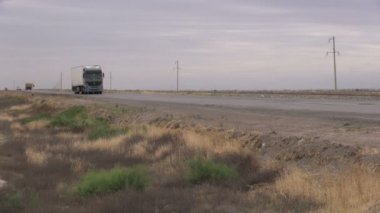 Türkmenistan ana karayolu üzerinde bir kamyon sürücüleri.