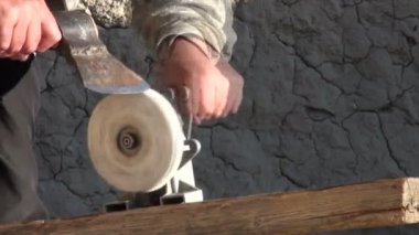 Bir adam baltayı biler.