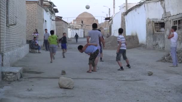 Barn spelar fotboll i backstreet — Stockvideo