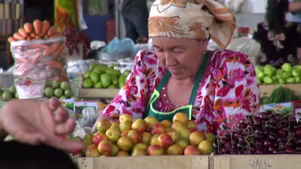 Женщина в вуали продает свежие фрукты — стоковое видео