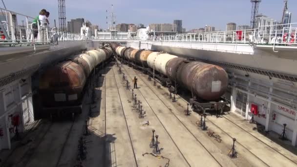 Carruagens de trem a óleo são empurradas em um navio — Vídeo de Stock