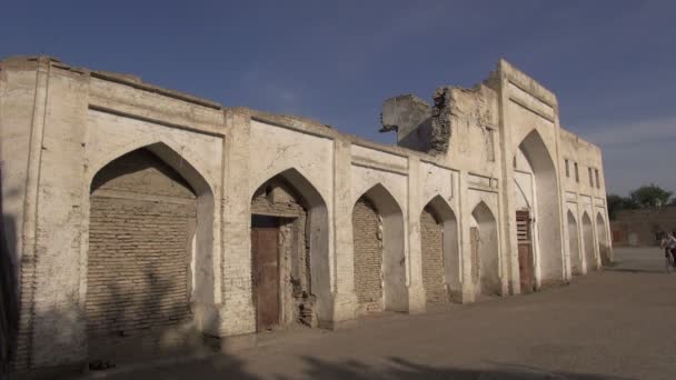 Man cycles past  madrassa building — Stock Video