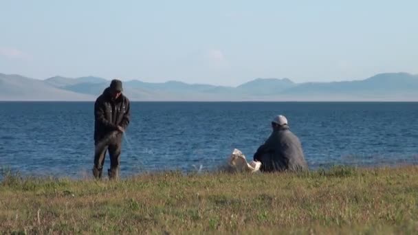 Dois homens estão separando redes de pesca — Vídeo de Stock