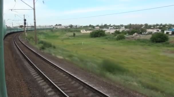 Езда на поезде мимо маленькой деревни . — стоковое видео