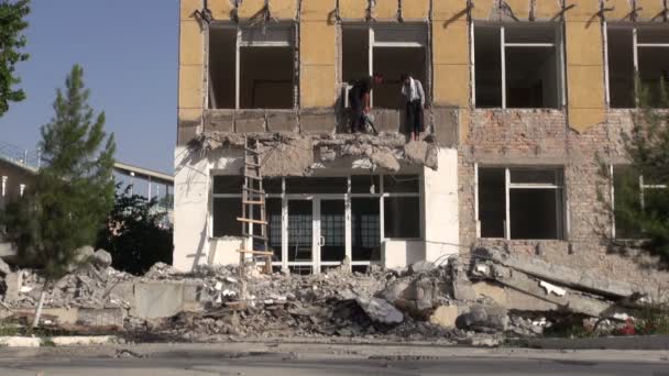 Los hombres están ocupados derribando el edificio — Vídeo de stock