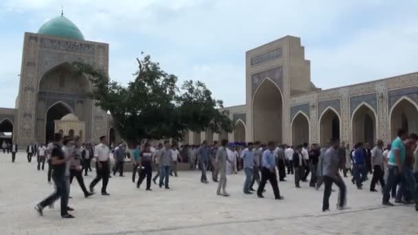 La gente sale de la mezquita Kalon — Vídeo de stock