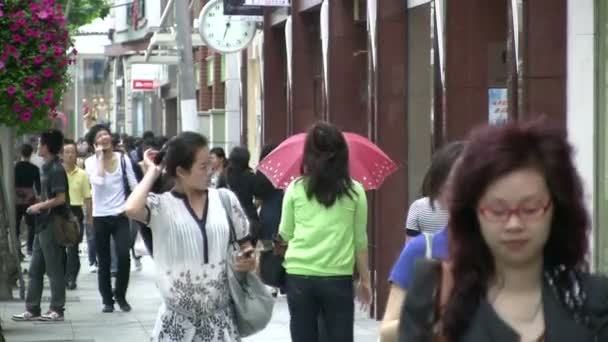 People walk through shopping street — Stock Video
