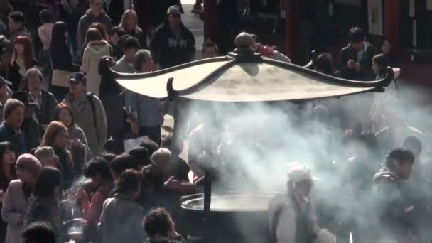 People gather to burn incense in temple — Stock Video