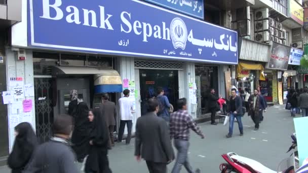 Mensen lopen langs een grote bank — Stockvideo