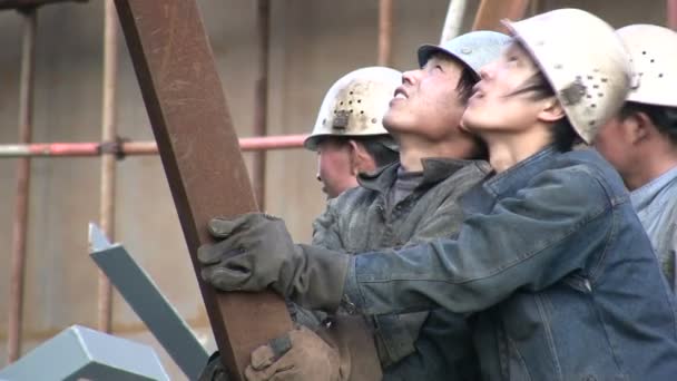 Kinesiska arbetare håller bitar av metall. — Stockvideo