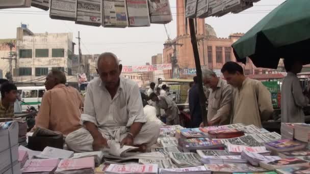 Um homem vende jornais. — Vídeo de Stock